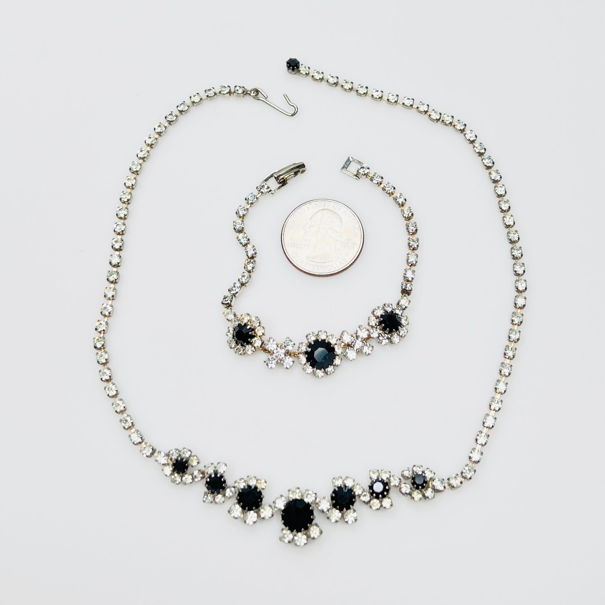 Matching 1950s rhinestone necklace and bracelet beside quarter for scale