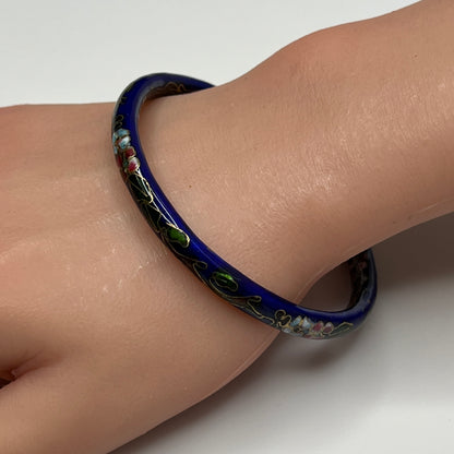 Dark blue cloisonné bangle bracelet with floral design on wrist