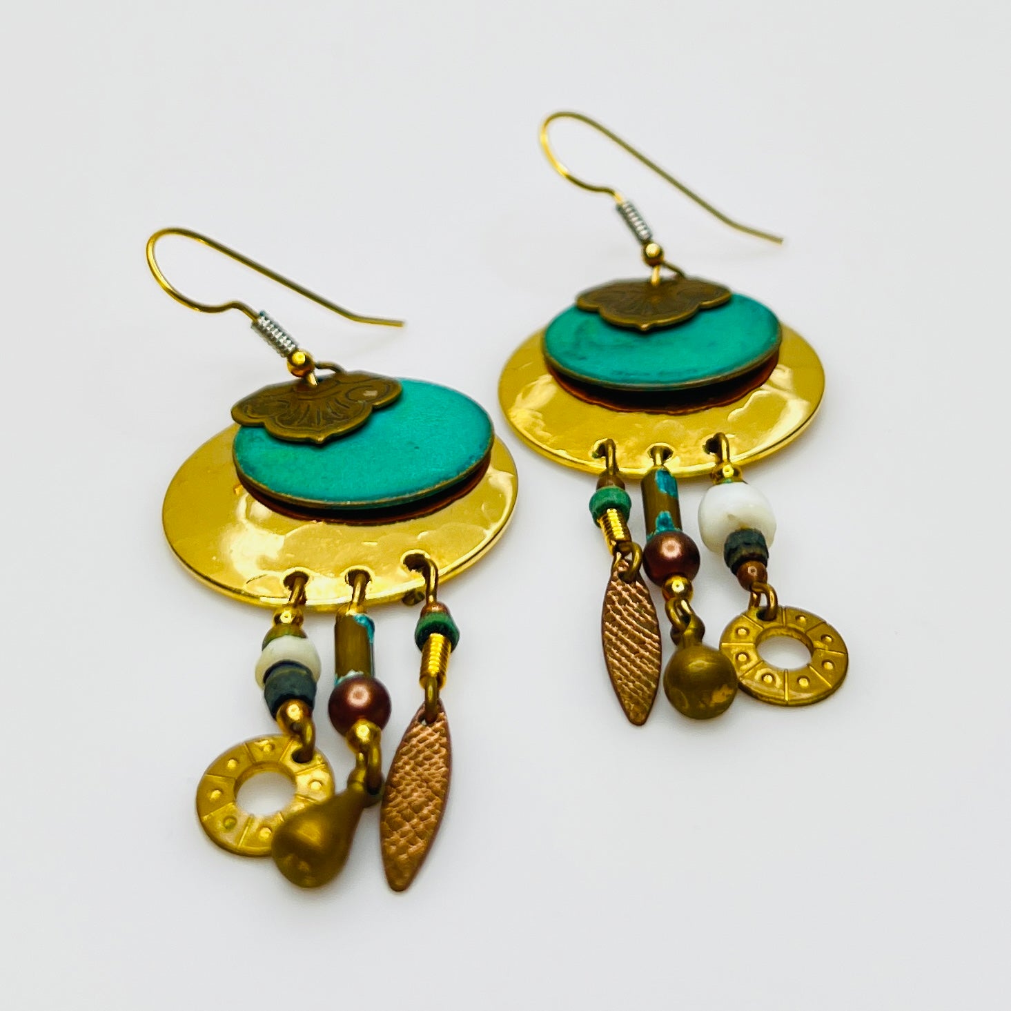 Close-up layered disc earrings with turquoise enamel center