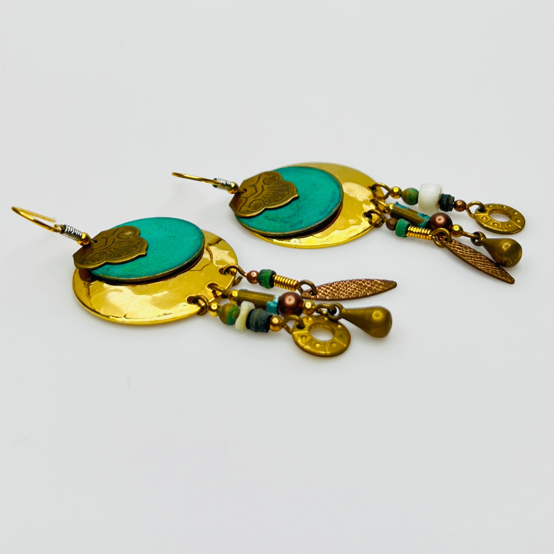 Close-up layered disc earrings with turquoise enamel center
