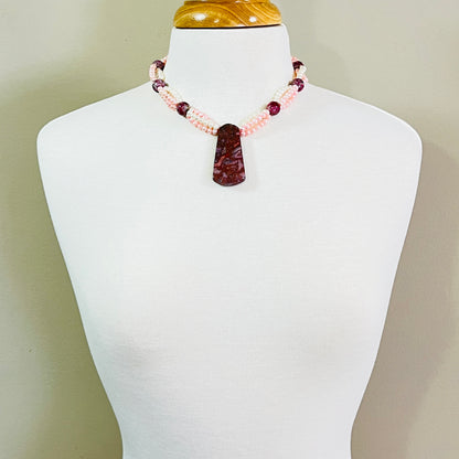 Triple strand pearl necklace featuring large Cotton Candy Agate pendant on display bust