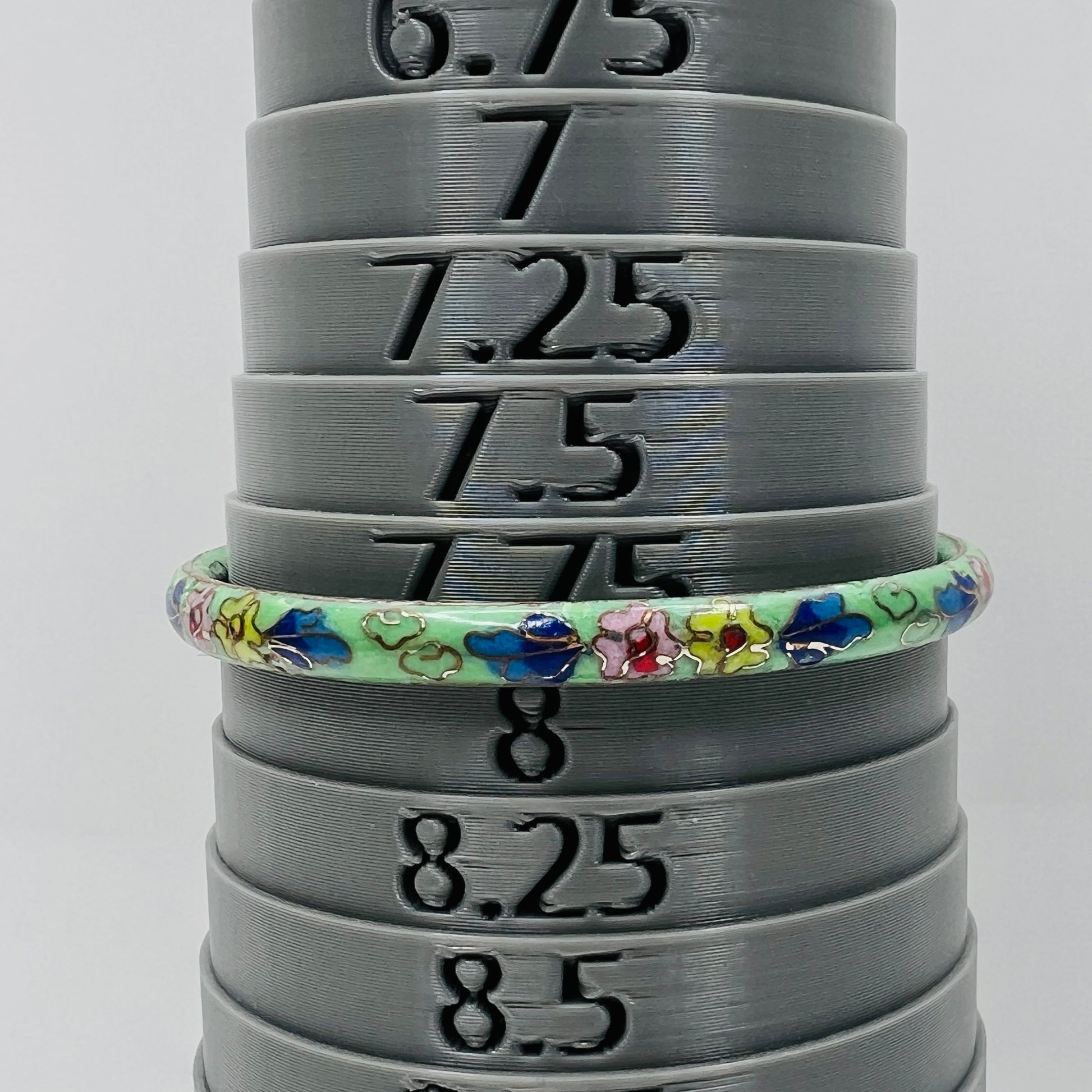 Cloisonne bangle on mandrel showing size and slim profile