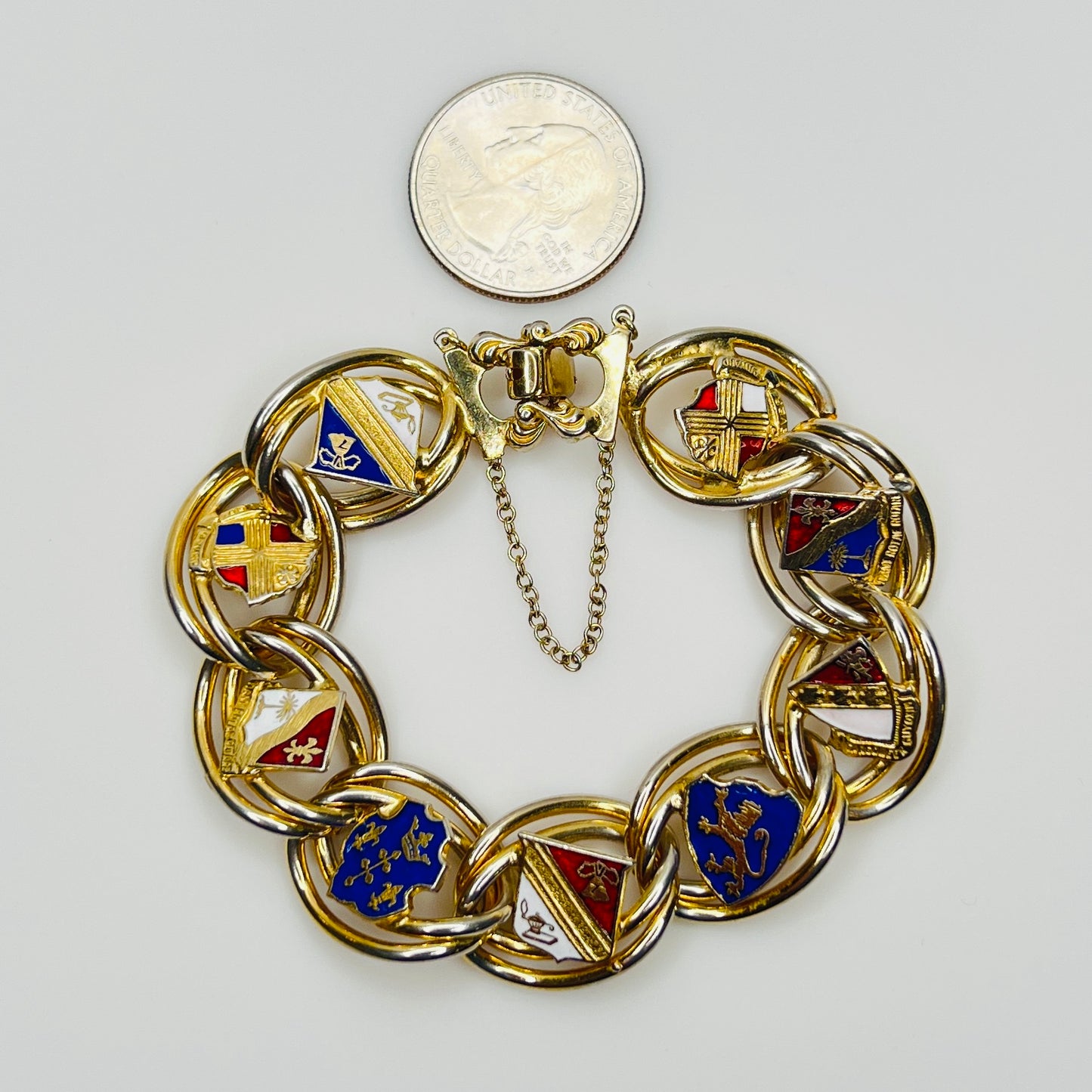 Gold tone heraldic bracelet beside quarter for scale
