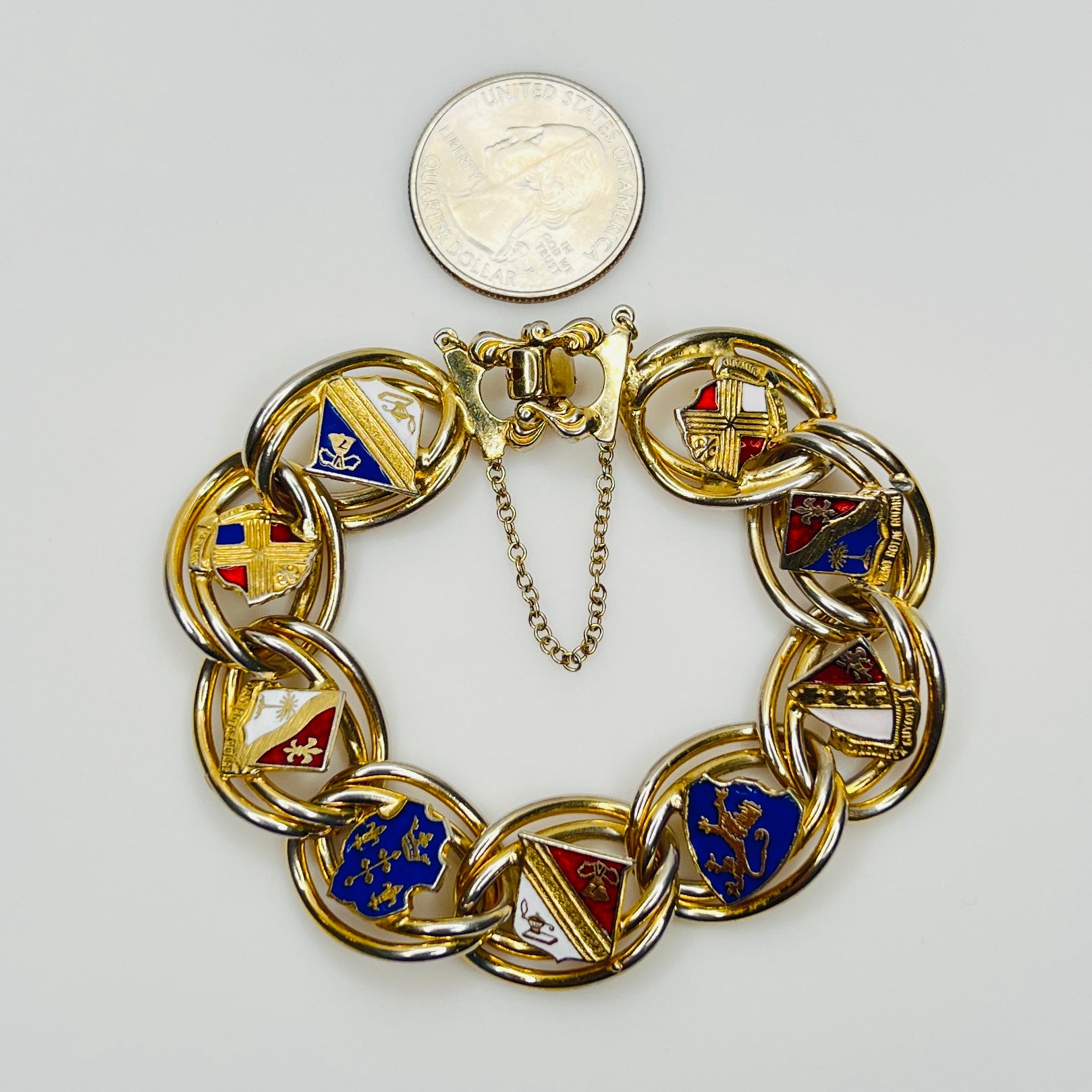 Gold tone heraldic bracelet beside quarter for scale
