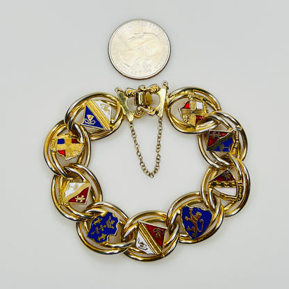 Gold tone heraldic bracelet beside quarter for scale