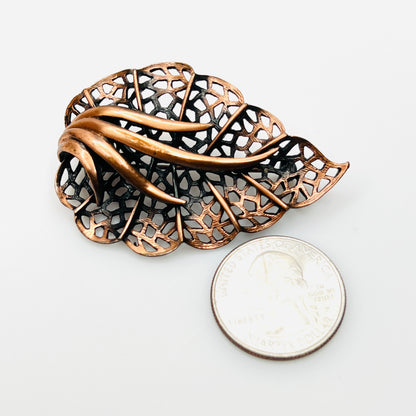Vintage copper filigree leaf brooch shown beside quarter for size comparison