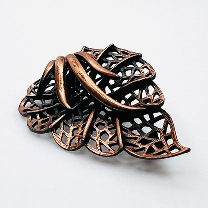 Side view of dimensional 1970s copper openwork leaf brooch