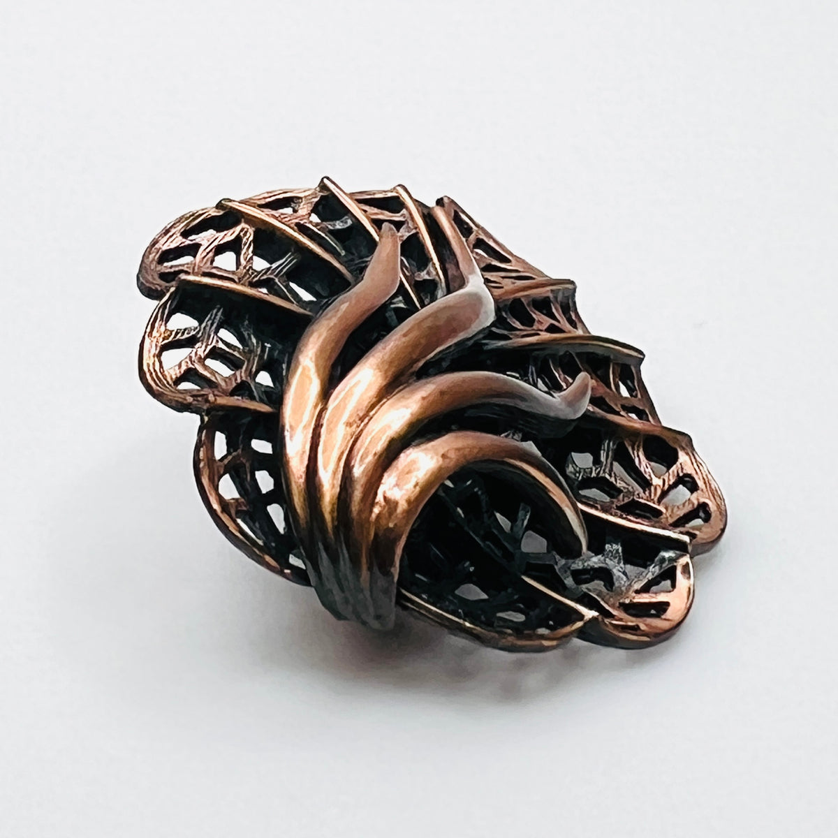 Side view of dimensional 1970s copper openwork leaf brooch