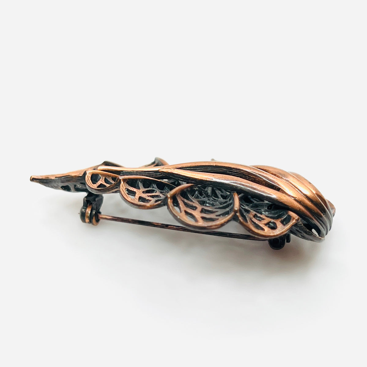 Side view of dimensional 1970s copper openwork leaf brooch