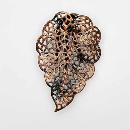 Reverse of vintage copper openwork leaf brooch showing pin and pierced design