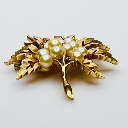 Side view of vintage Crown Trifari gold leaf brooch with faux pearls