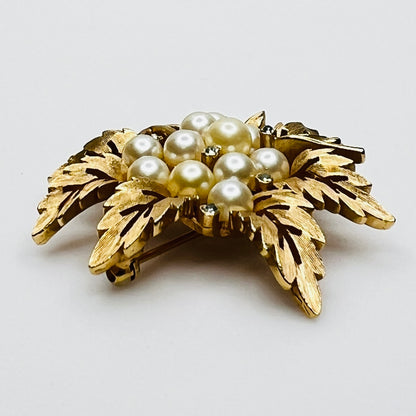 Side view of vintage Crown Trifari gold leaf brooch with faux pearls