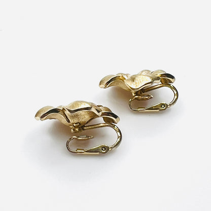 Side view of vintage Crown Trifari gold flower clip earrings.