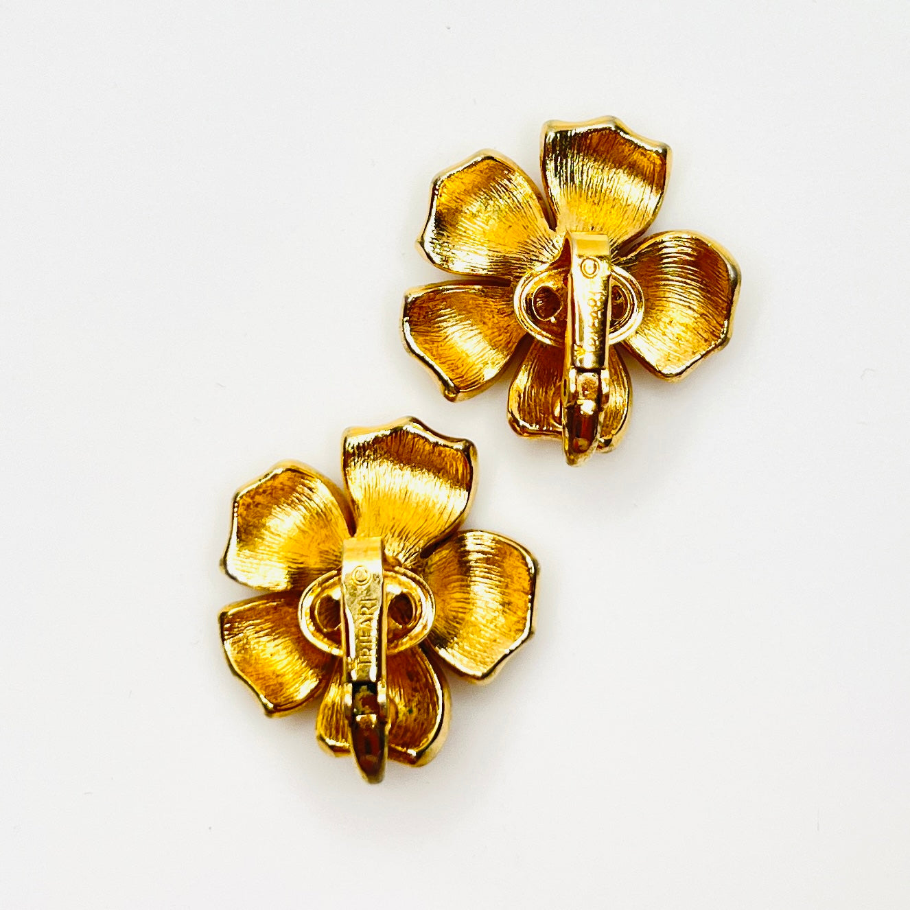 Back of signed Crown Trifari gold flower clip-on earrings.