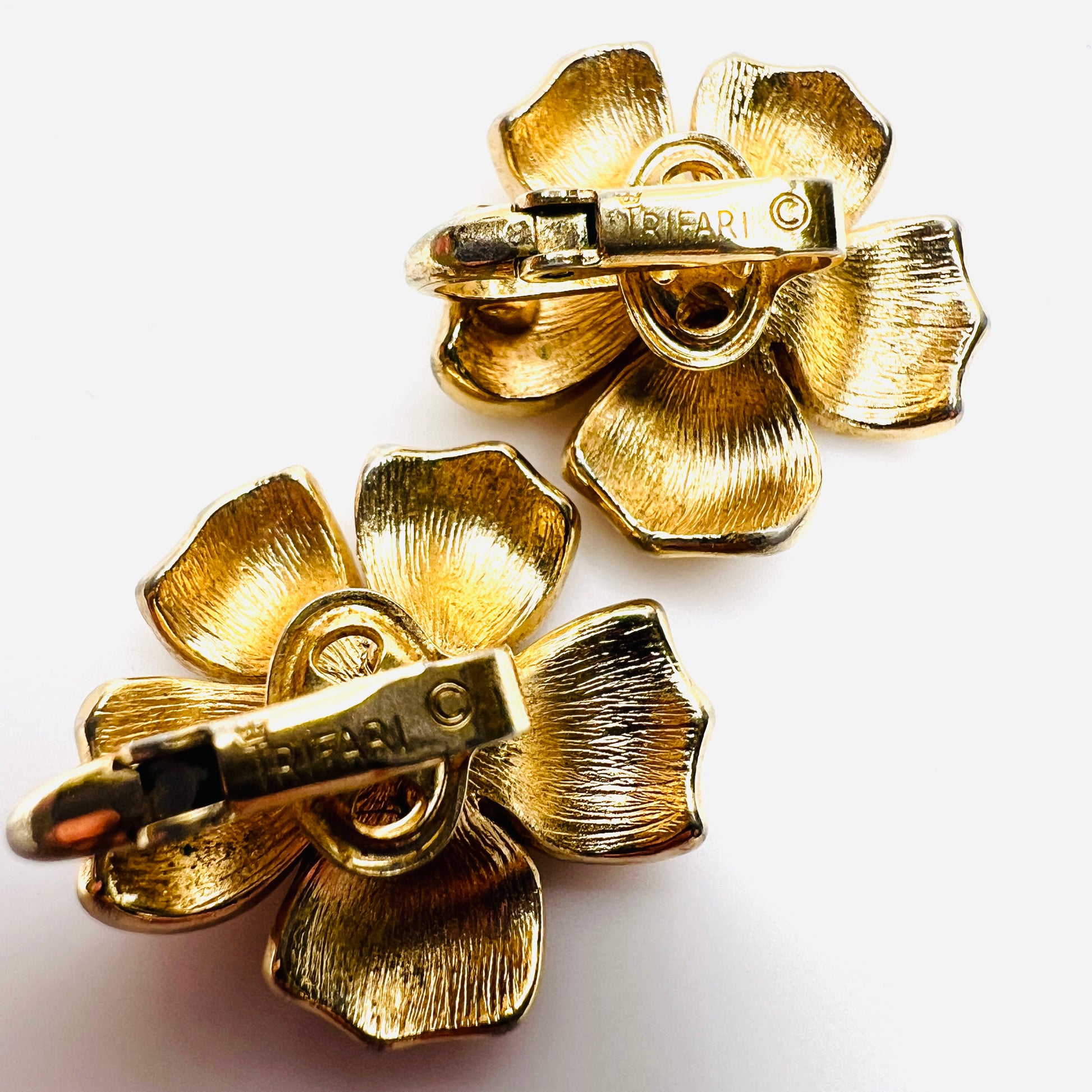 Close-up of Crown Trifari signature on vintage clip earrings.
