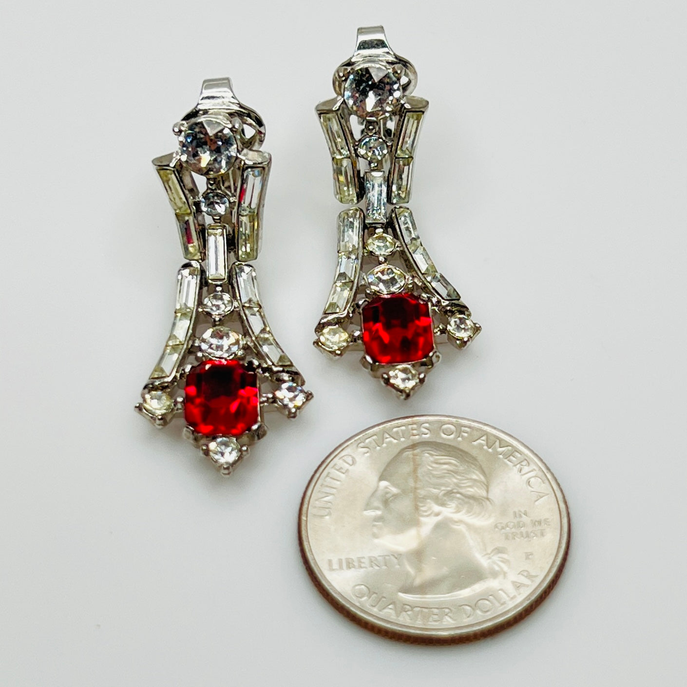 Trifari earrings next to coin for size reference