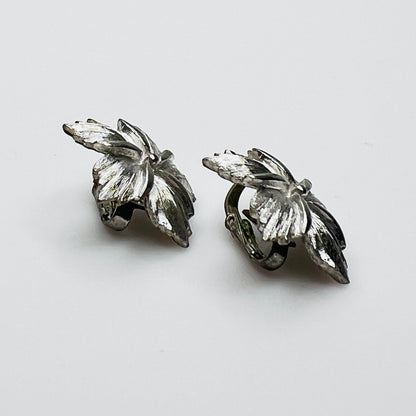 Side view of dimensional silver flower clip earrings