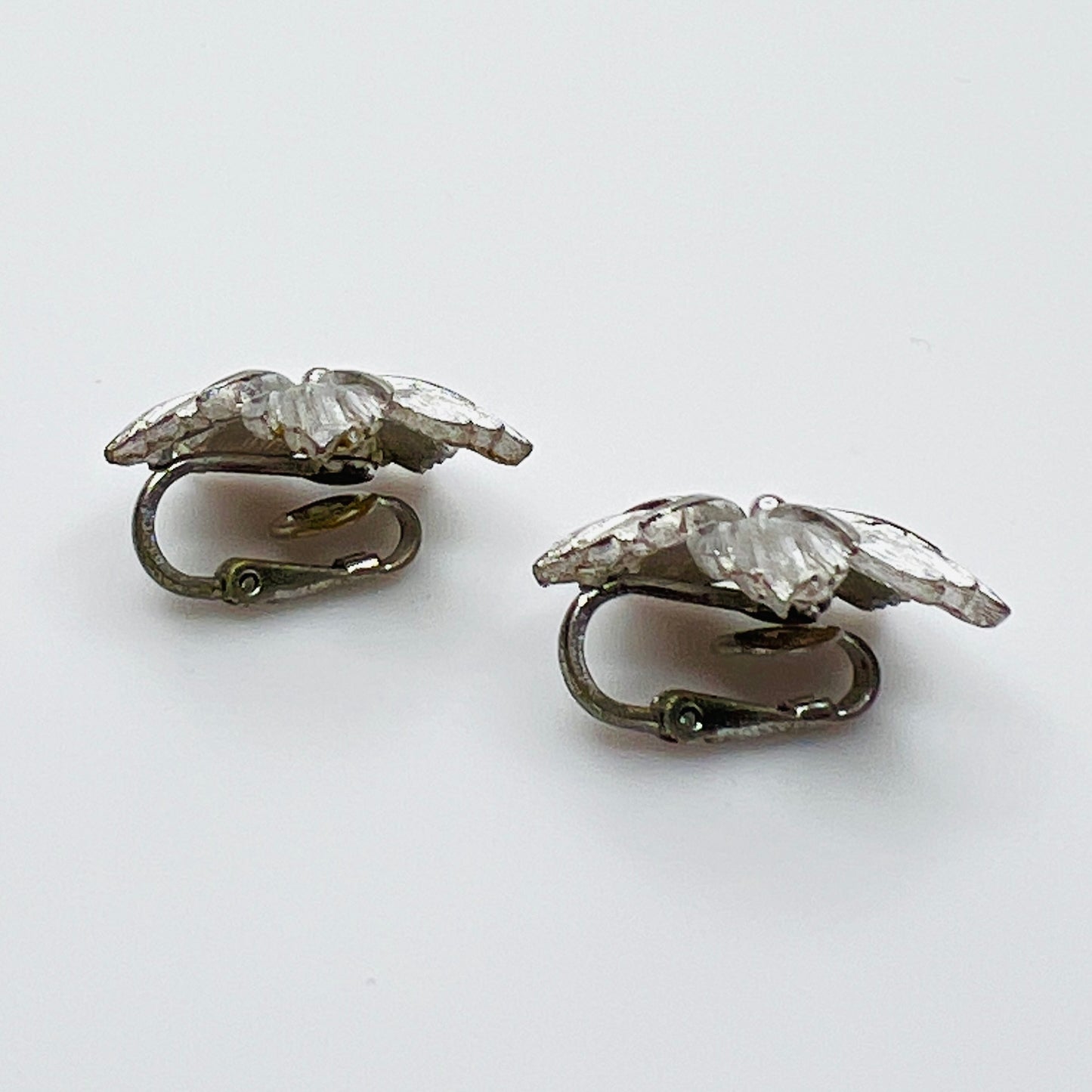 Side view of dimensional silver flower clip earrings