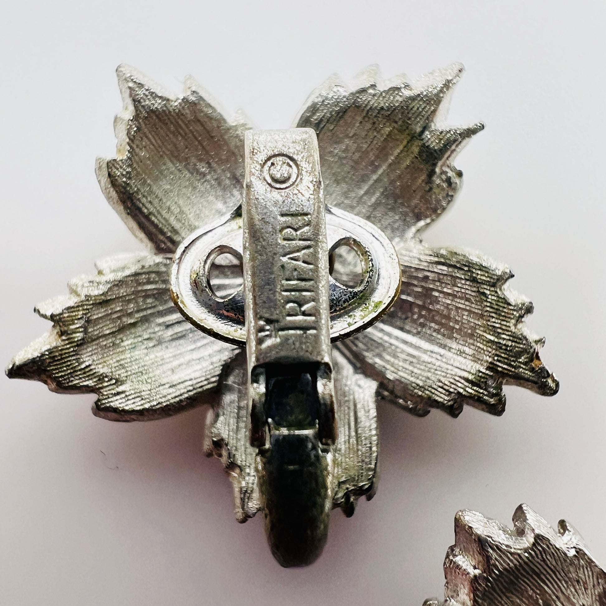 Close up of Crown Trifari mark on vintage earring clip
