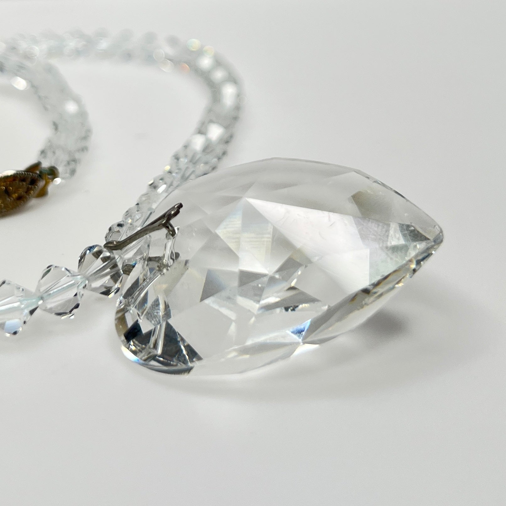 Close-up of vintage faceted crystal heart pendant on sparkling crystal bead necklace