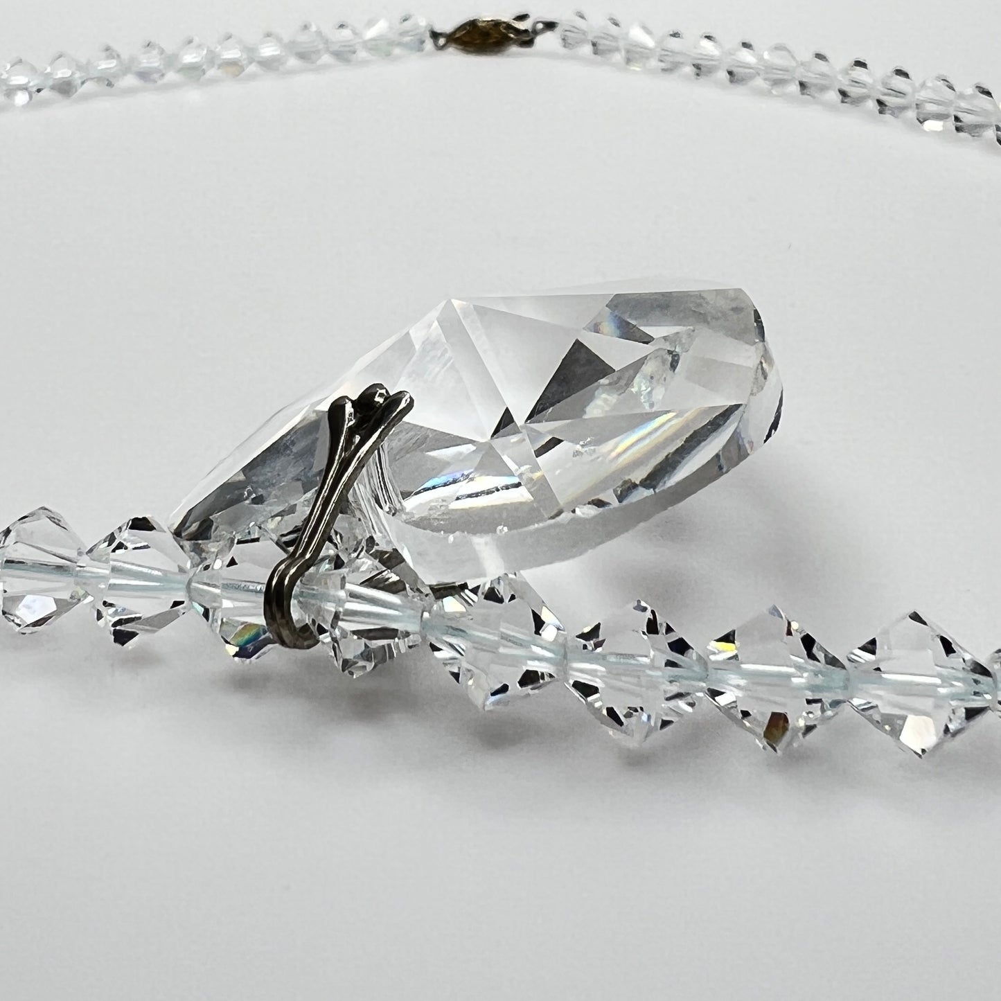 Close-up of vintage faceted crystal heart pendant on sparkling crystal bead necklace