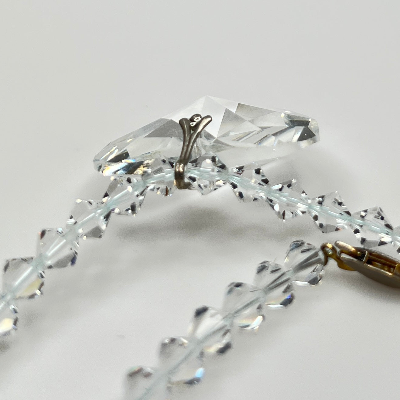 Close-up of vintage faceted crystal heart pendant on sparkling crystal bead necklace