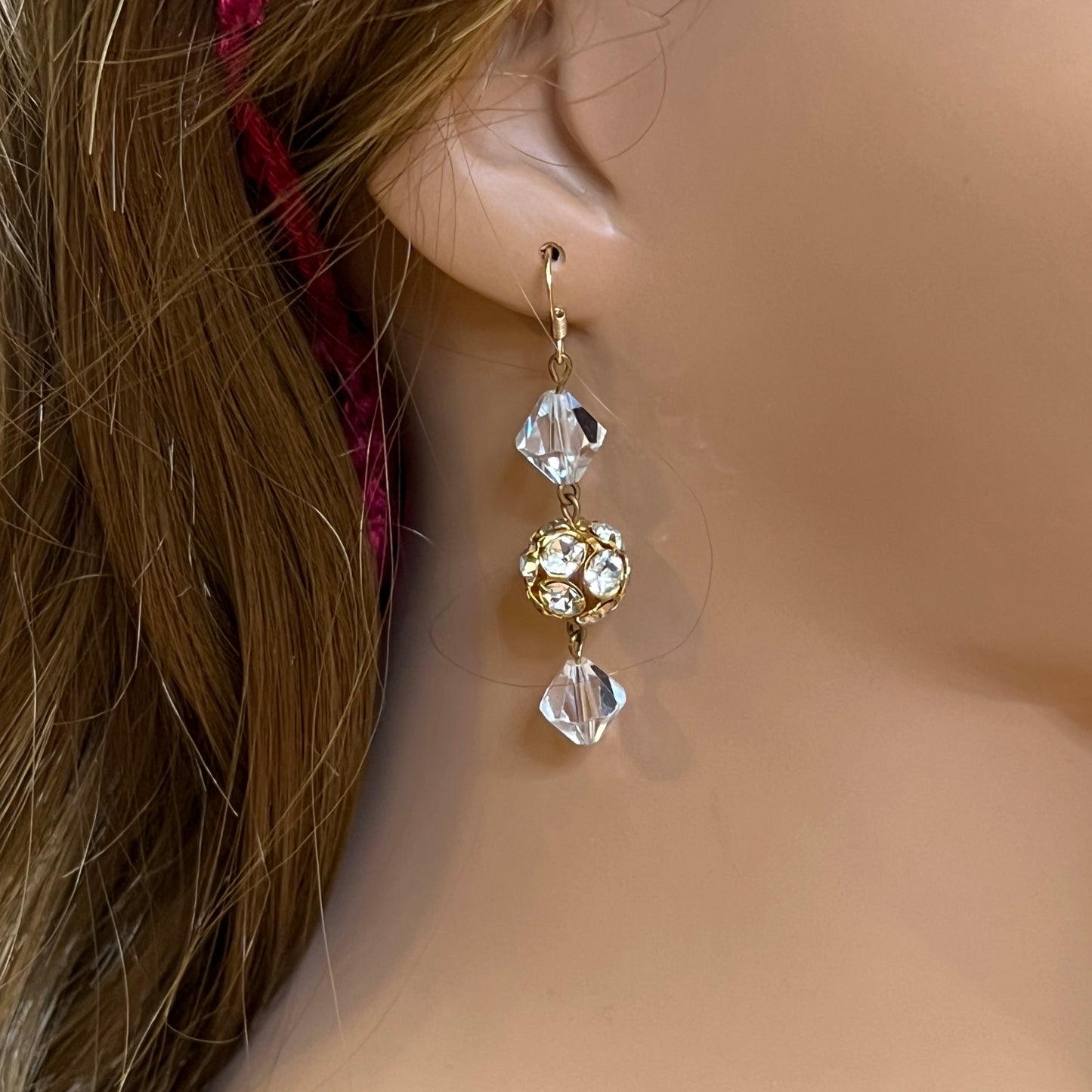 Close-up of clear vintage crystal drop earrings with sparkle detail