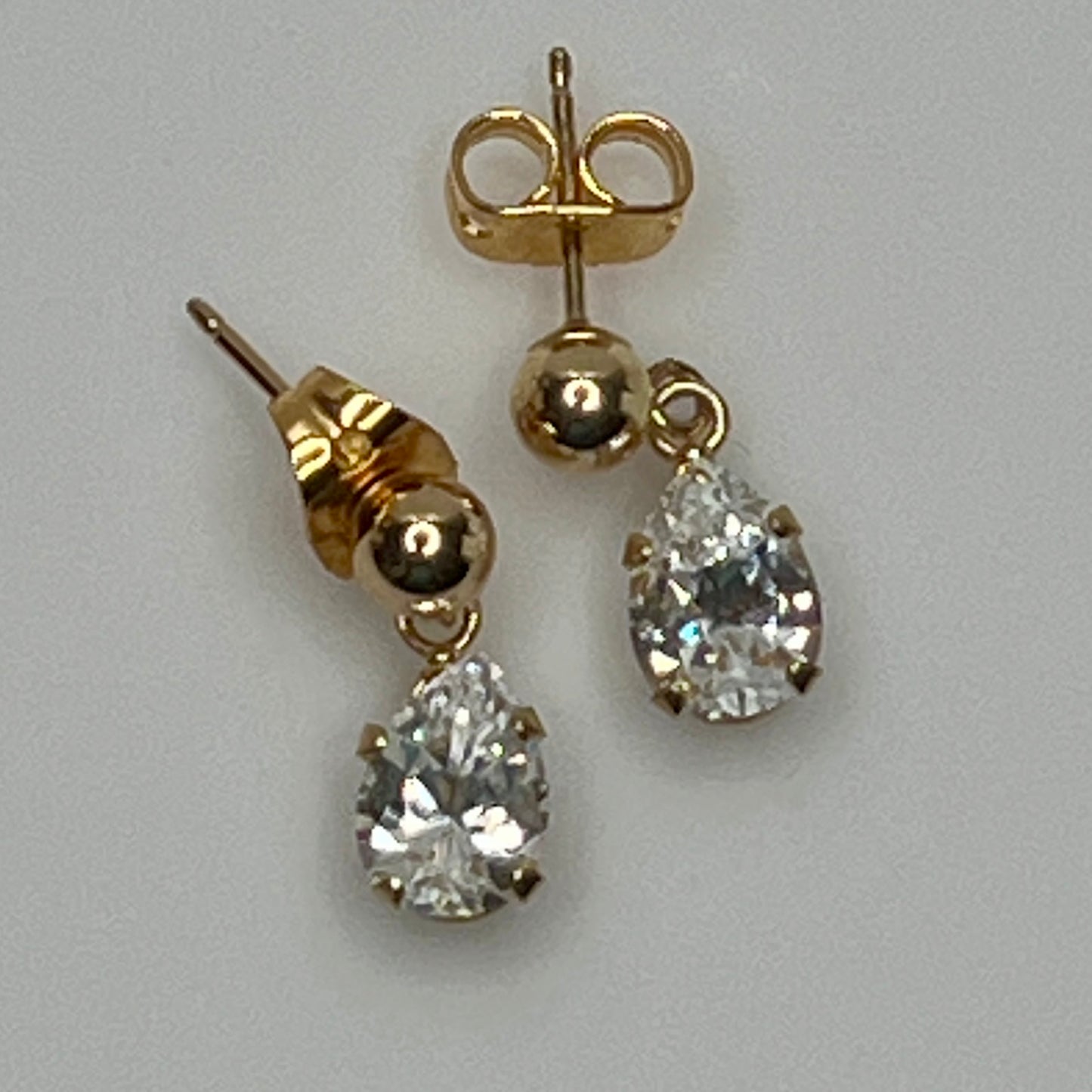 Close-up of vintage gold drop earrings with prong-set stones