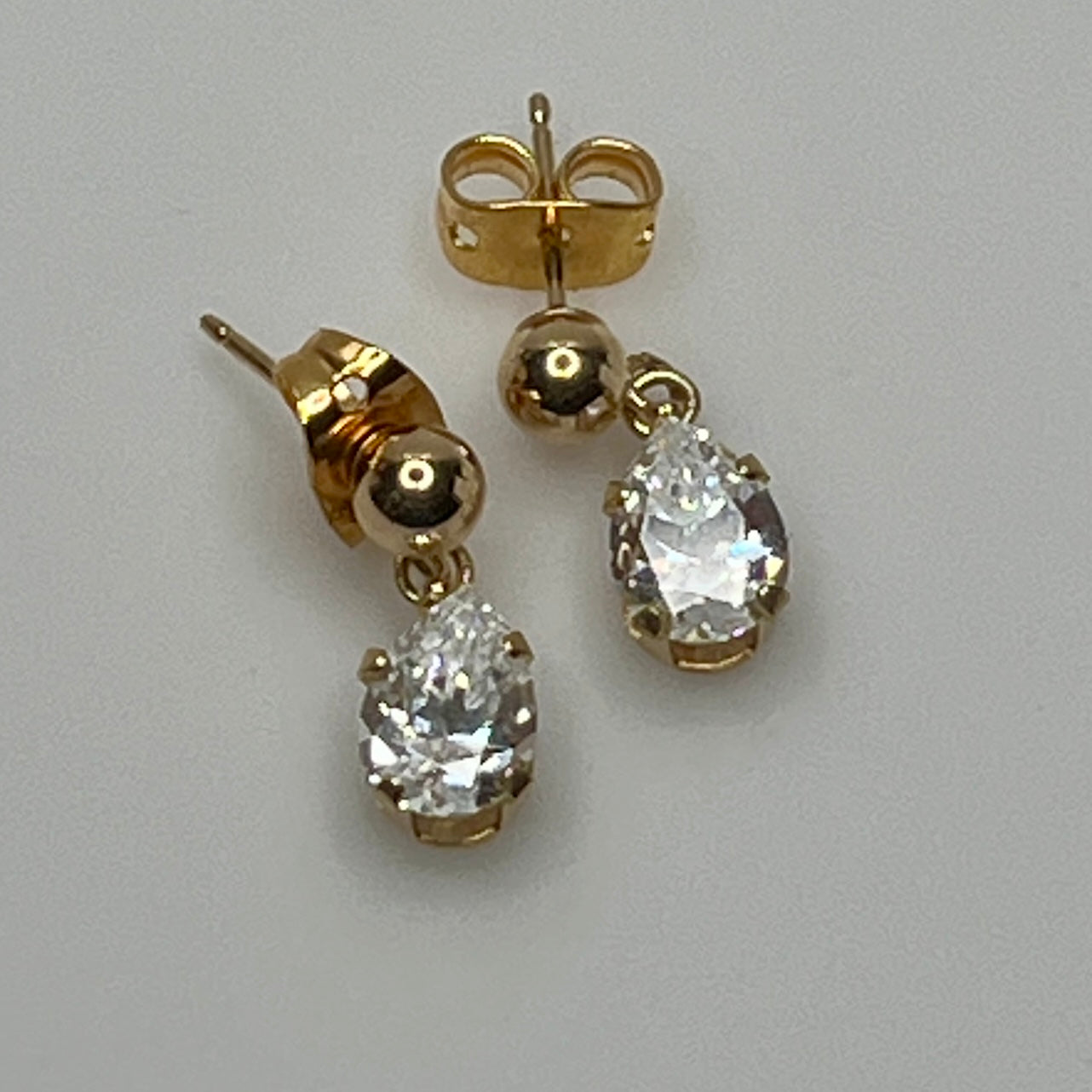 Close-up of vintage gold drop earrings with prong-set stones