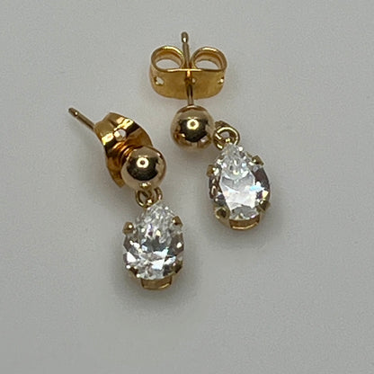 Close-up of vintage gold drop earrings with prong-set stones