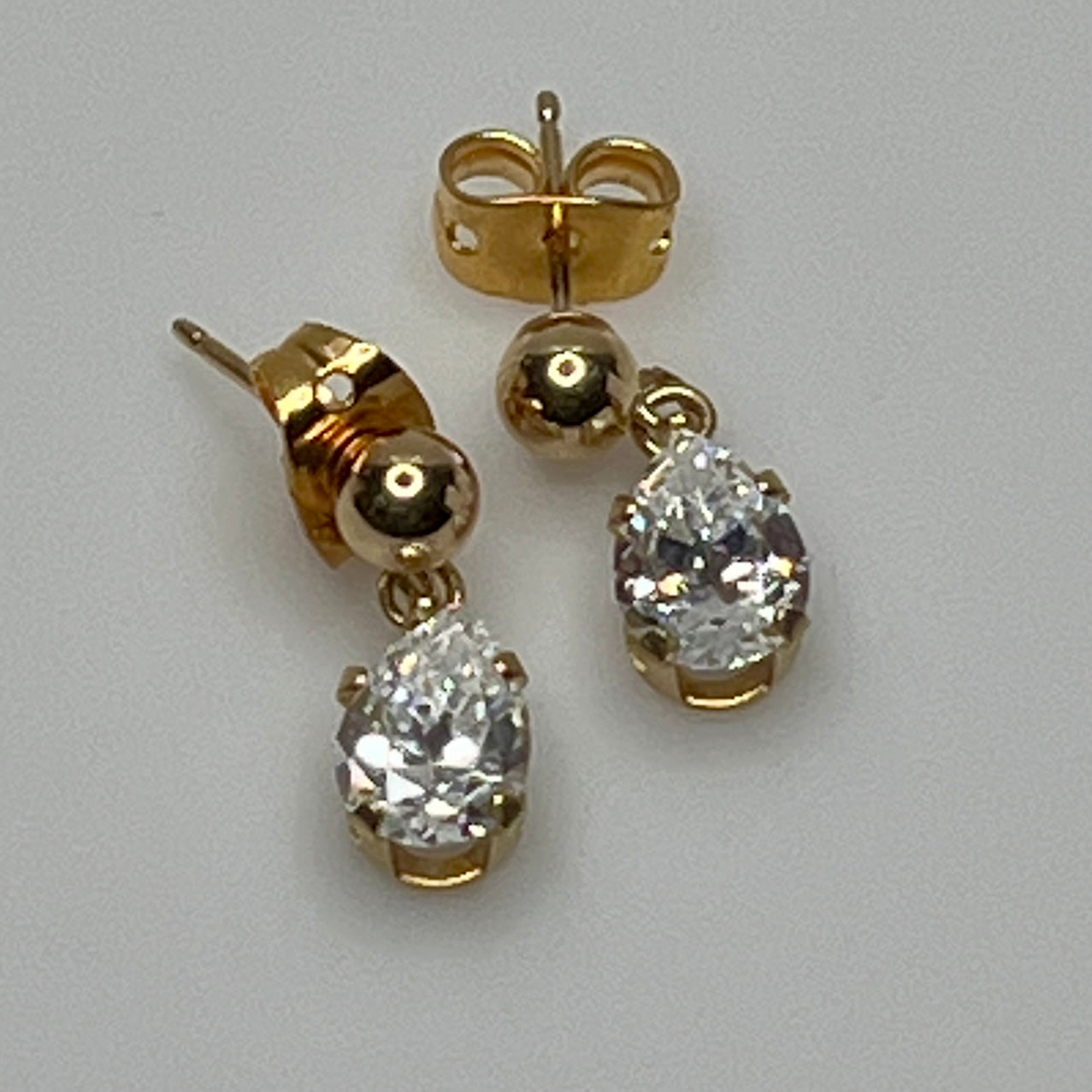 Close-up of vintage gold drop earrings with prong-set stones