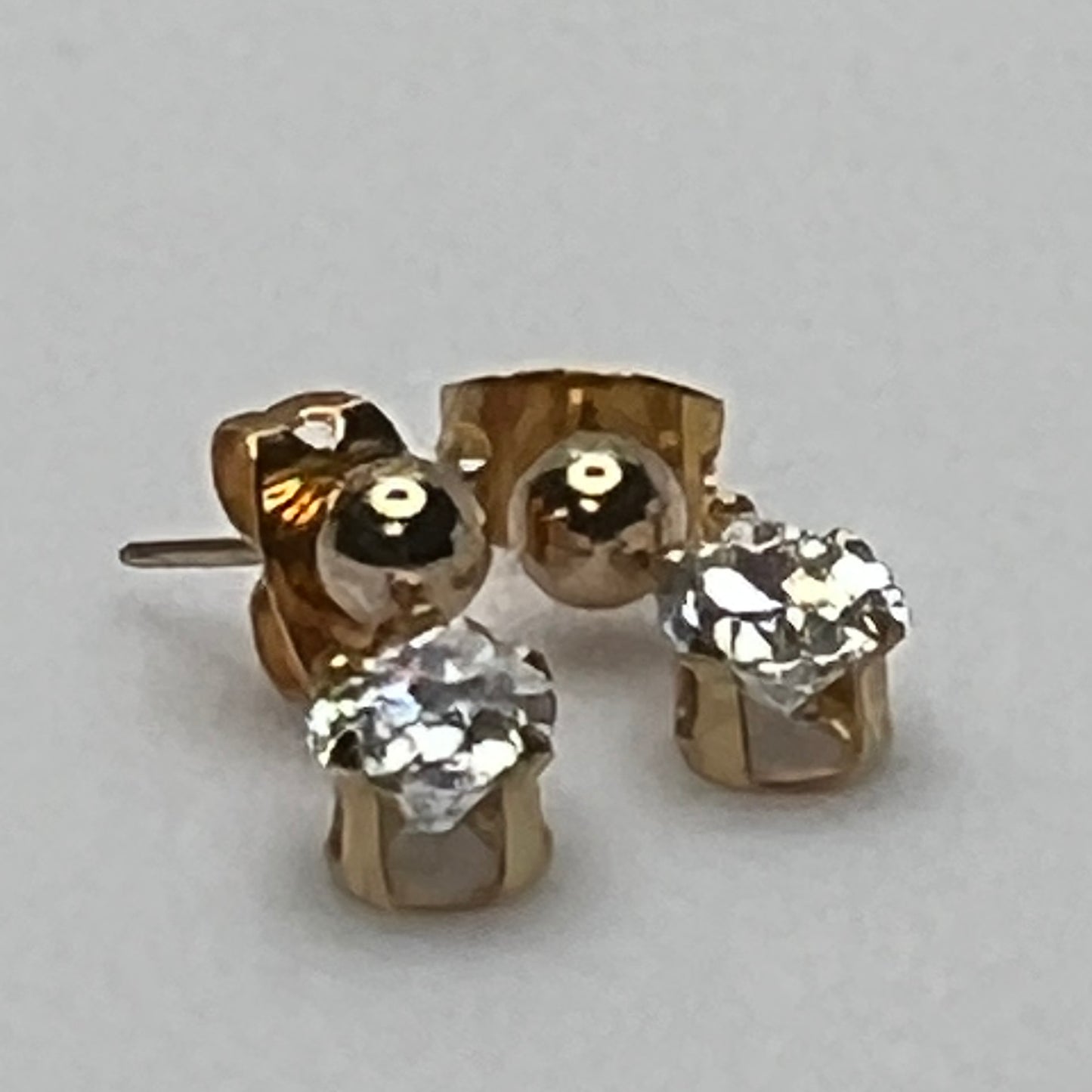 Close-up of vintage gold drop earrings with prong-set stones