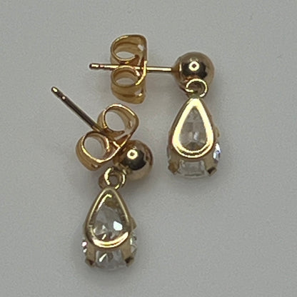 Close-up of vintage gold drop earrings with prong-set stones