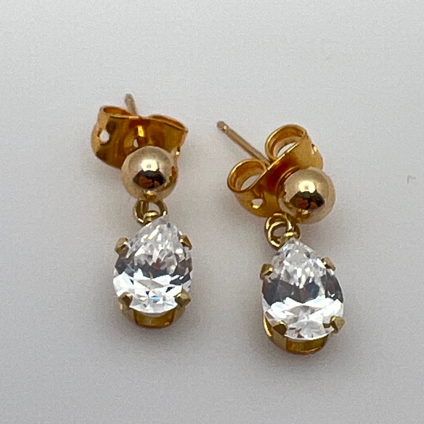 Close-up of vintage gold drop earrings with prong-set stones
