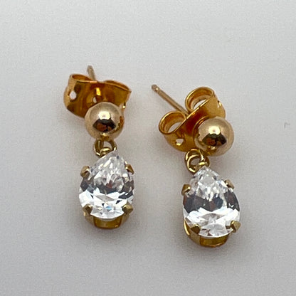 Close-up of vintage gold drop earrings with prong-set stones