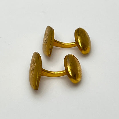 Side view of curved bar Edwardian-style gold cufflinks with floral engraving