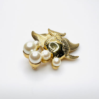 Side view of dimensional gold tone fish brooch with creamy faux pearls