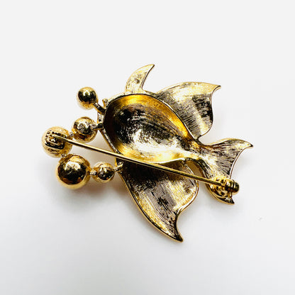 Reverse of vintage gold tone fish brooch showing pin back and textured fins