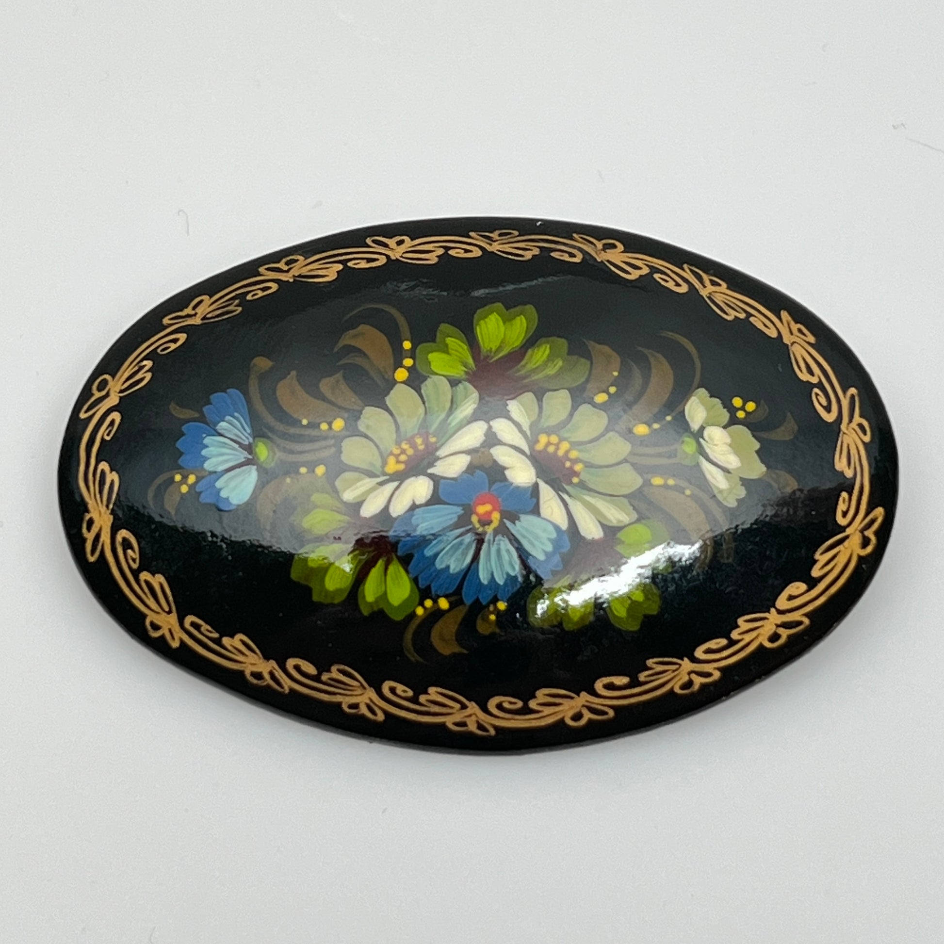 Russian black lacquer brooch with hand-painted floral design and gold border