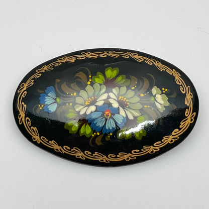 Russian black lacquer brooch with hand-painted floral design and gold border