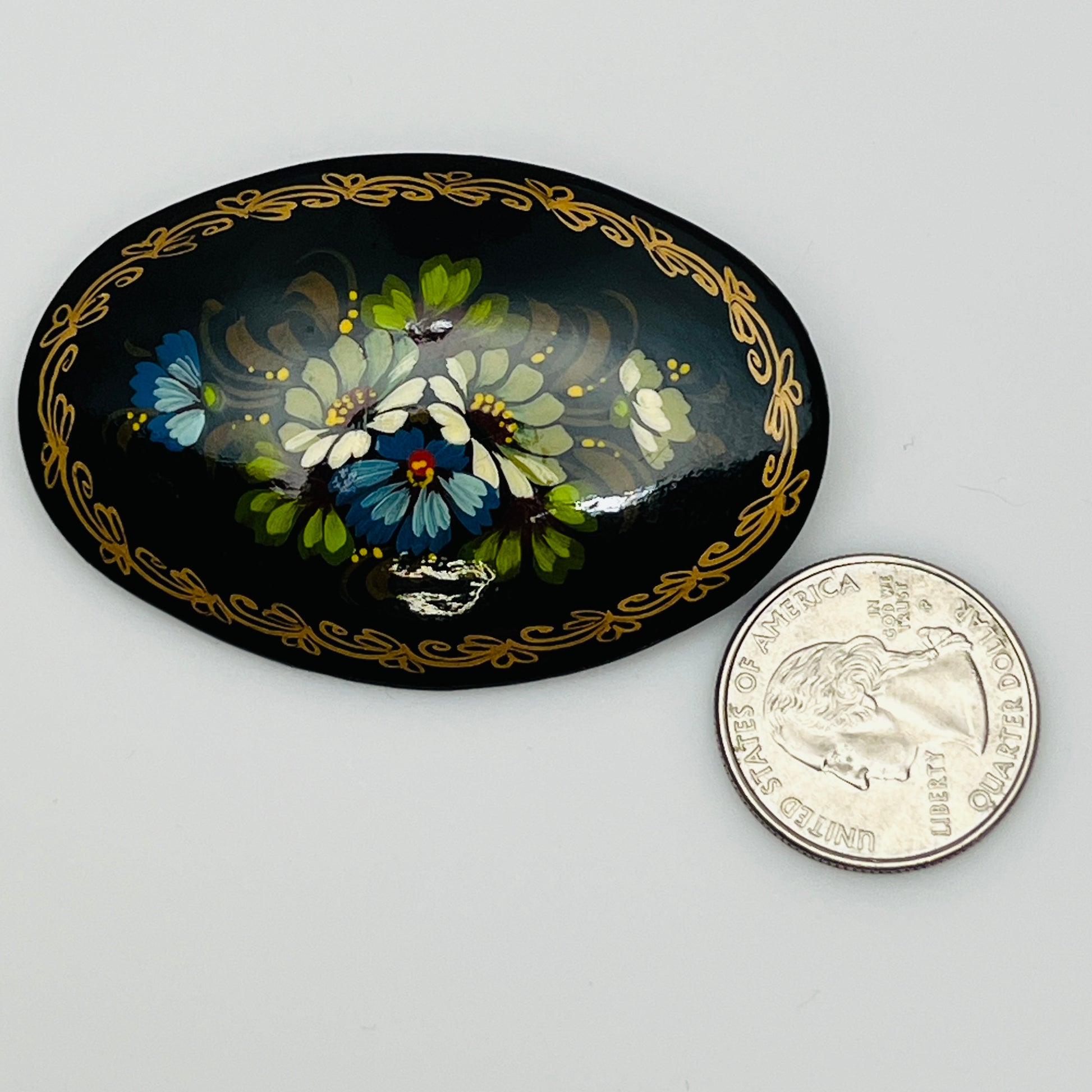 Russian black lacquer brooch with hand-painted floral design and gold border