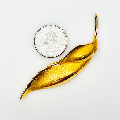 Giovanni gold tone leaf brooch shown beside quarter for size comparison