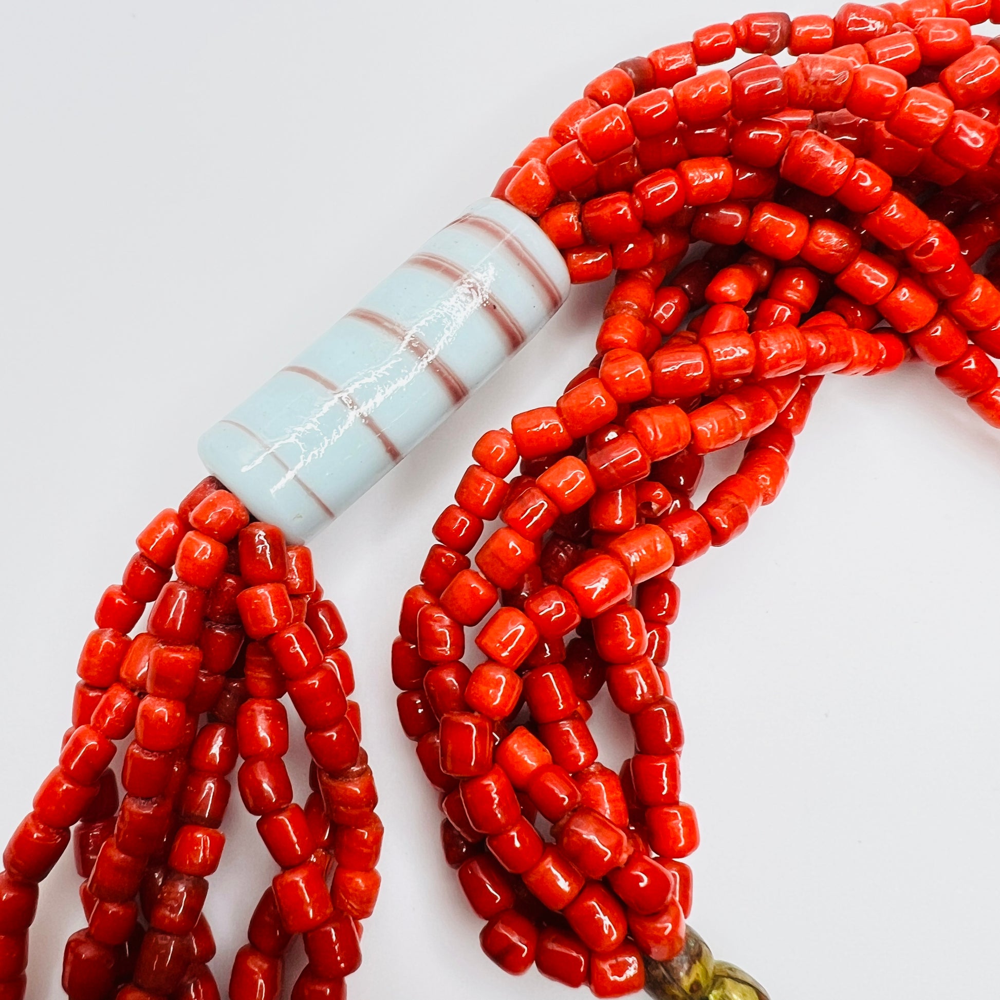 Close up of red glass bead strands with ceramic tube bead