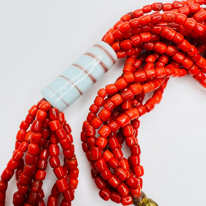 Close up of red glass bead strands with ceramic tube bead
