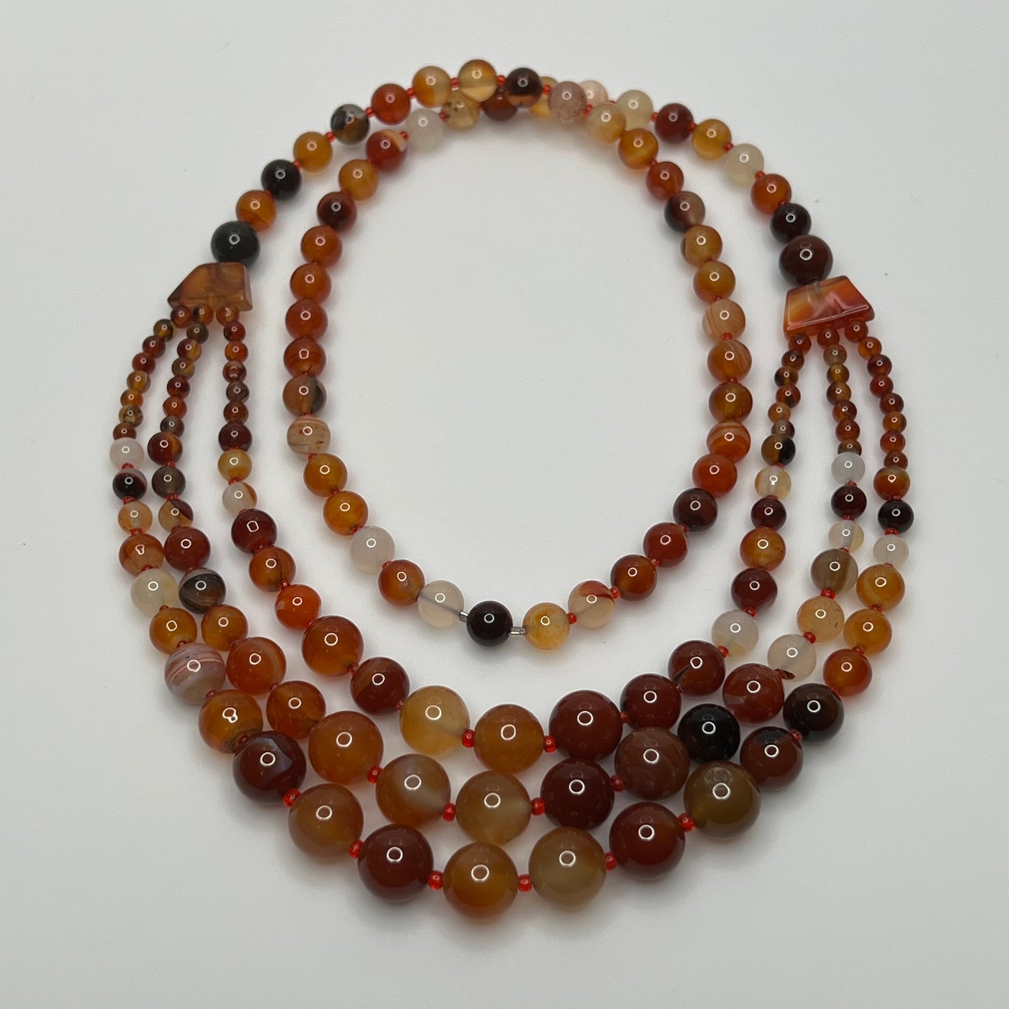 1960s-style over-the-head glass bead necklace with red and amber hues