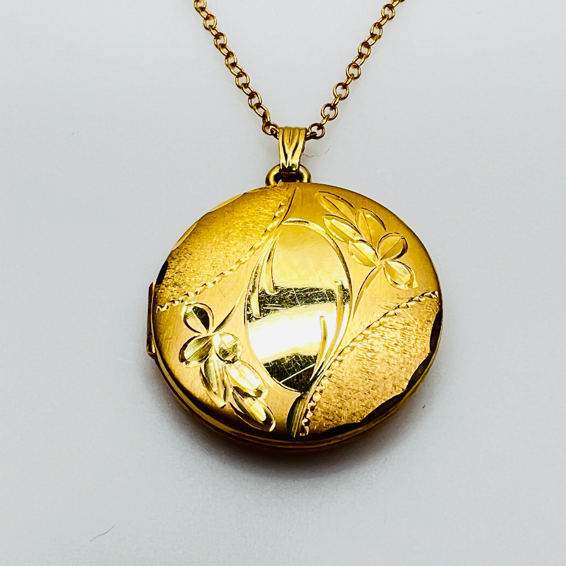 Close-up etched floral design H.F. Barrows gold locket