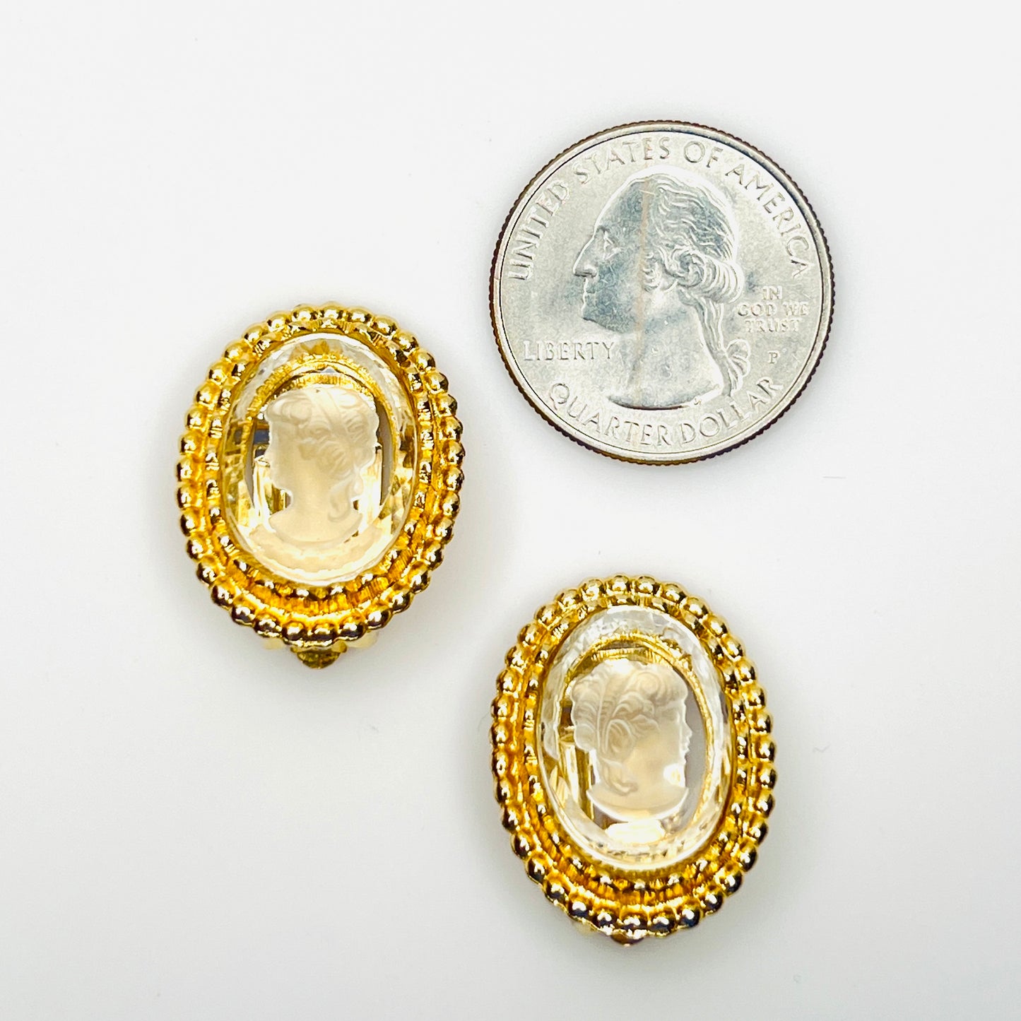 Oval vintage glass cameo clip earrings shown beside quarter for scale
