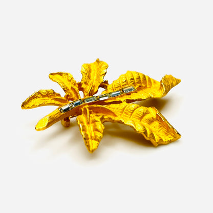 Side profile of vintage textured gold tone leaf brooch with baguette rhinestones