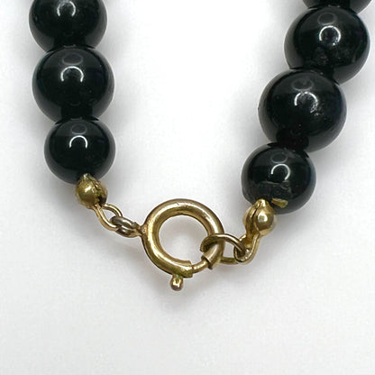 Gold-tone spring ring clasp detail on vintage 1980s mixed media necklace