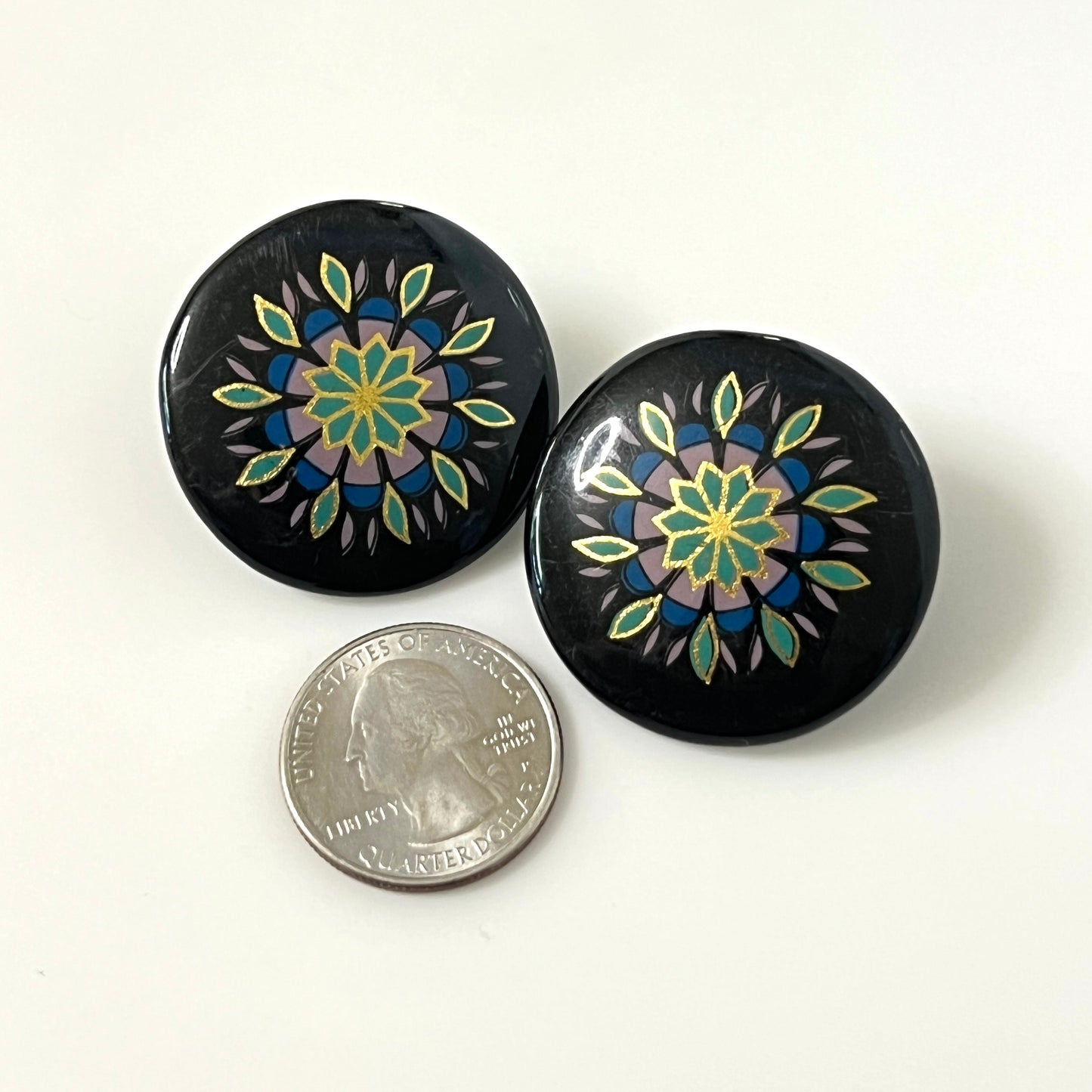 Matching hand-painted floral stud earrings in black, turquoise, blue, and gold enamel